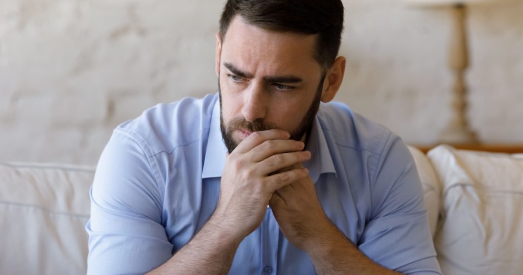 Worried concerned millennial business man thinking over bad news, problem solving, feeling stressed, depressed, frustrated, coping with nervous breakdown, emotional crisis. Negative emotions concept
