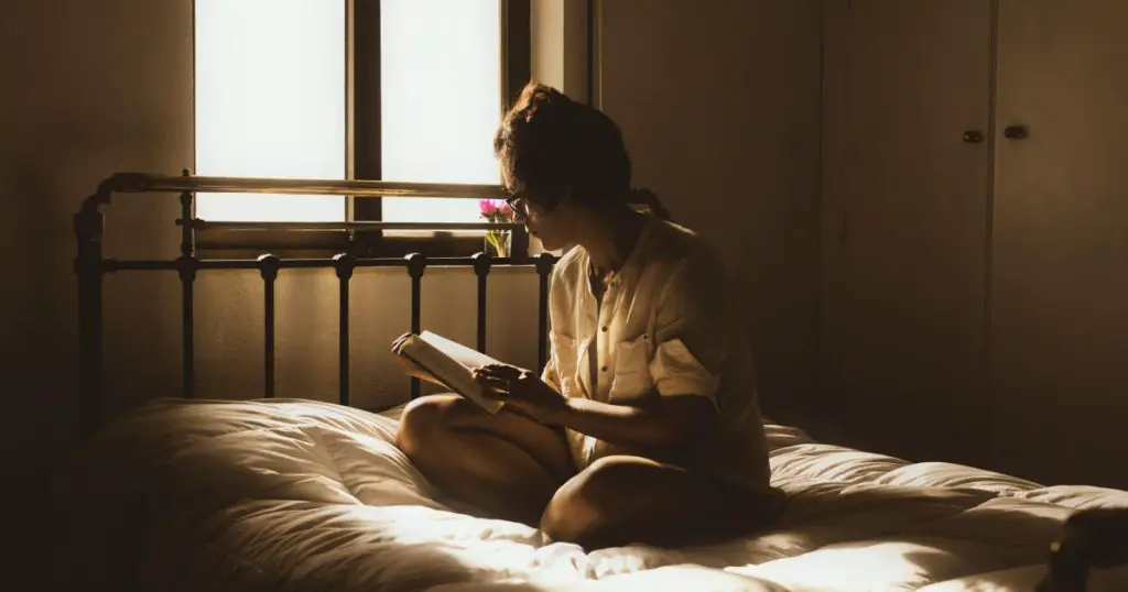 Read woman diary. Read woman in her room at sunset reading a book dressed in a silk shirt. A woman sits near the window and holds a book in her hands. woman reading a book alone. reading girl sad

