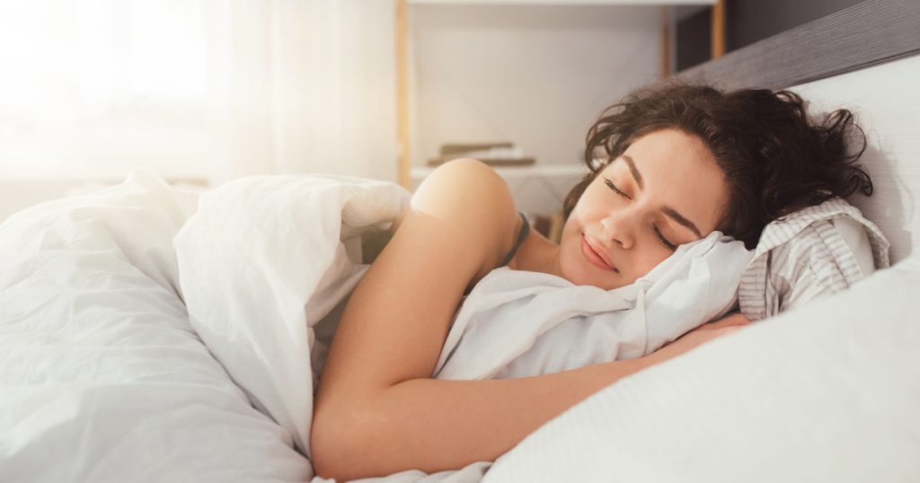 Feeling calmness. Sleepy female keeping eyes closed while dreaming about future vacation or sleeping at the bedroom. Stock photo
