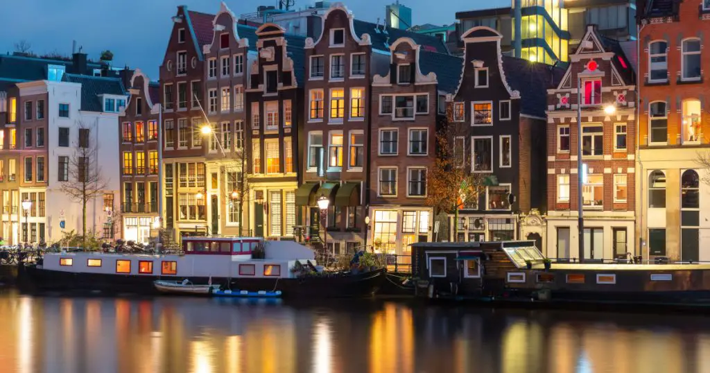 Evening Amsterdam canal Amstel with typical dutch houses at night, Holland, Netherlands.
