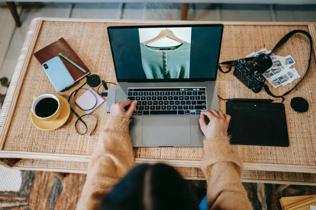 Faceless photographer with photo on laptop screen at home
