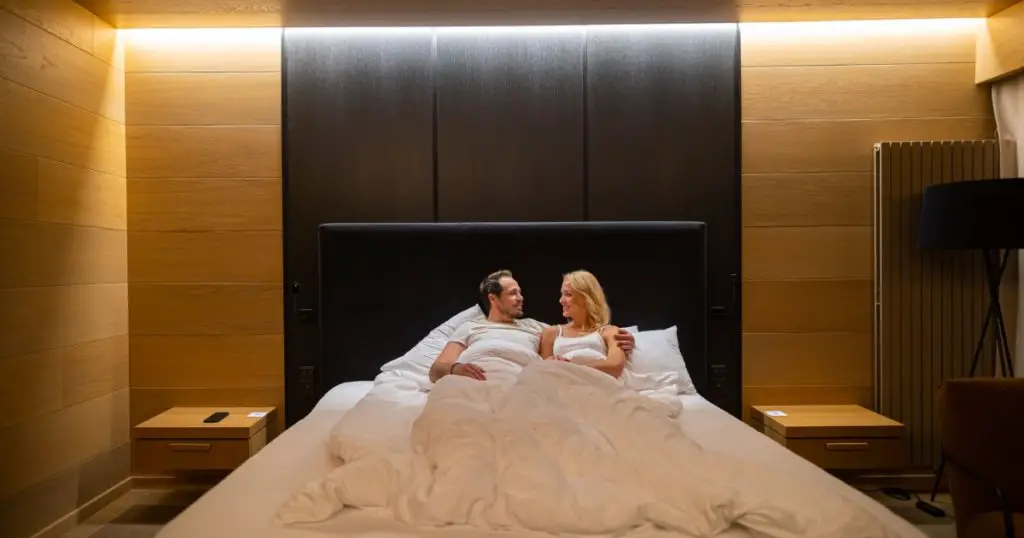 The romantic couple lying in bed in a hotel room