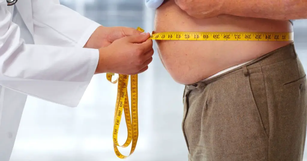 Doctor measuring obese man waist body fat. Obesity and weight loss.
