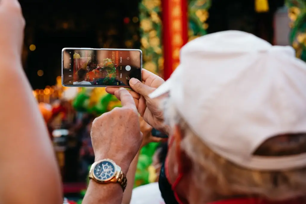 An old man pointing at a mobile screen