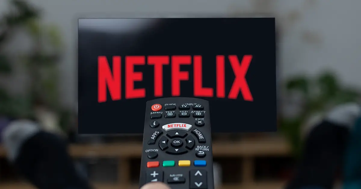 Remote being pointed at TV displaying Netflix logo