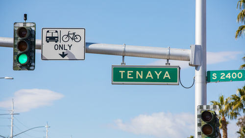 Street name sign of Tenaya Way in Las Vegas, NV, USA. Intersection of W Sahara Avenue at S 2400 block. Modern traffic light with surveillance camera and lane restriction sign on the left.