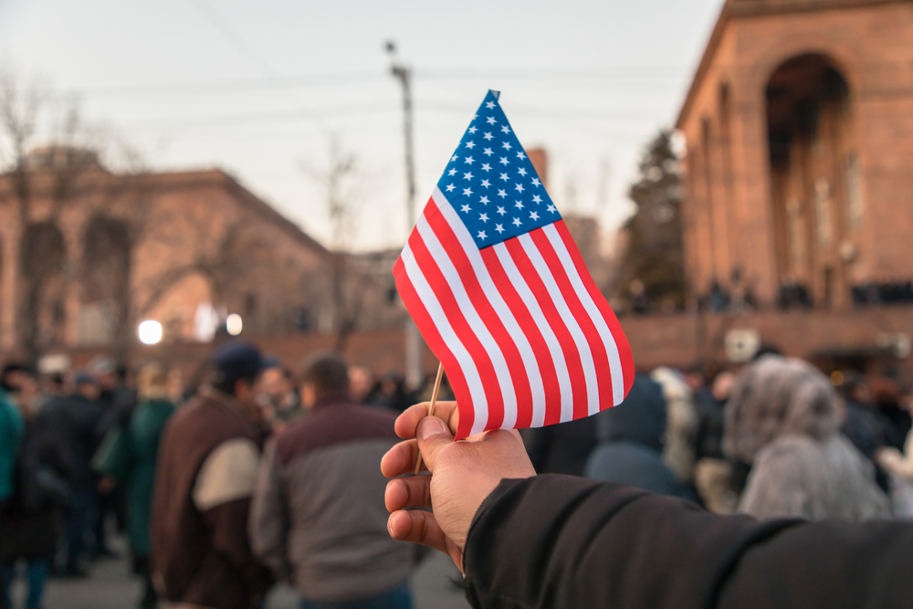 man holding American flag in demonstration