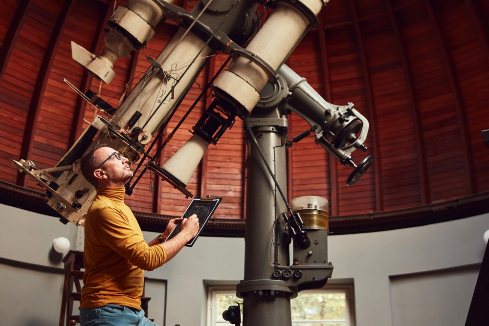 man looking through telescope
