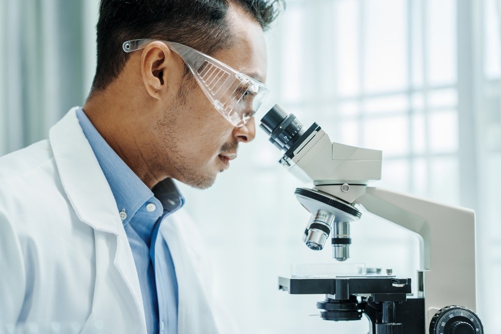 man looking through microscope