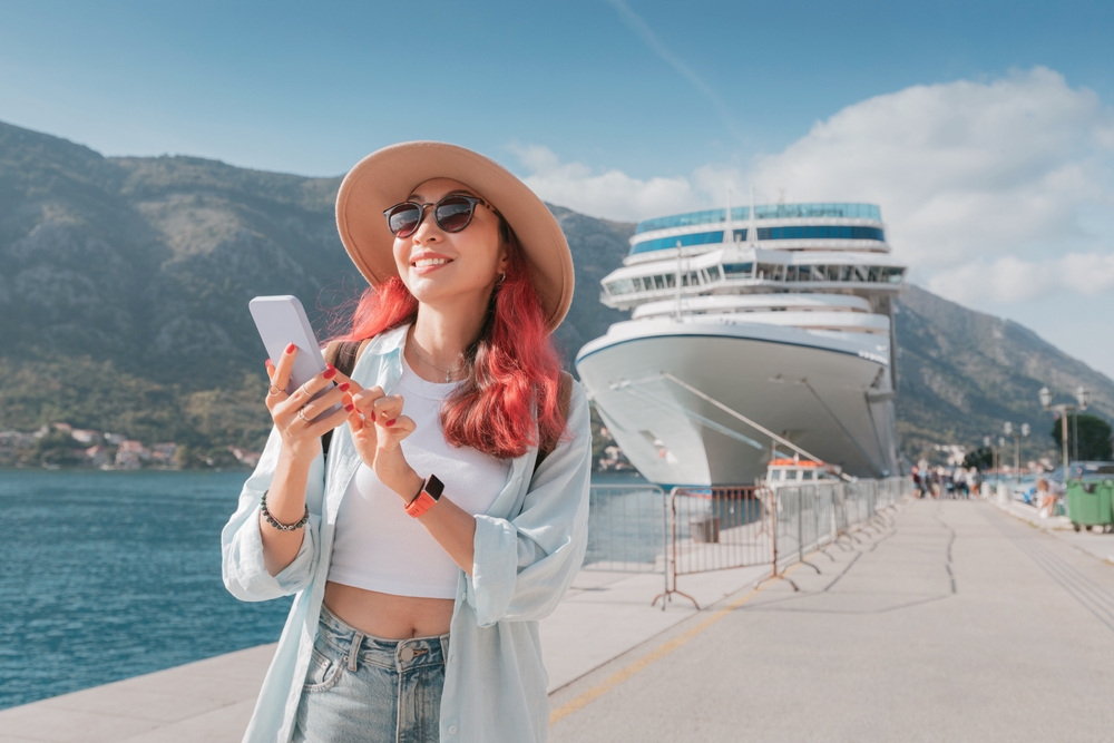 woman standing on dock infront of crusie ship