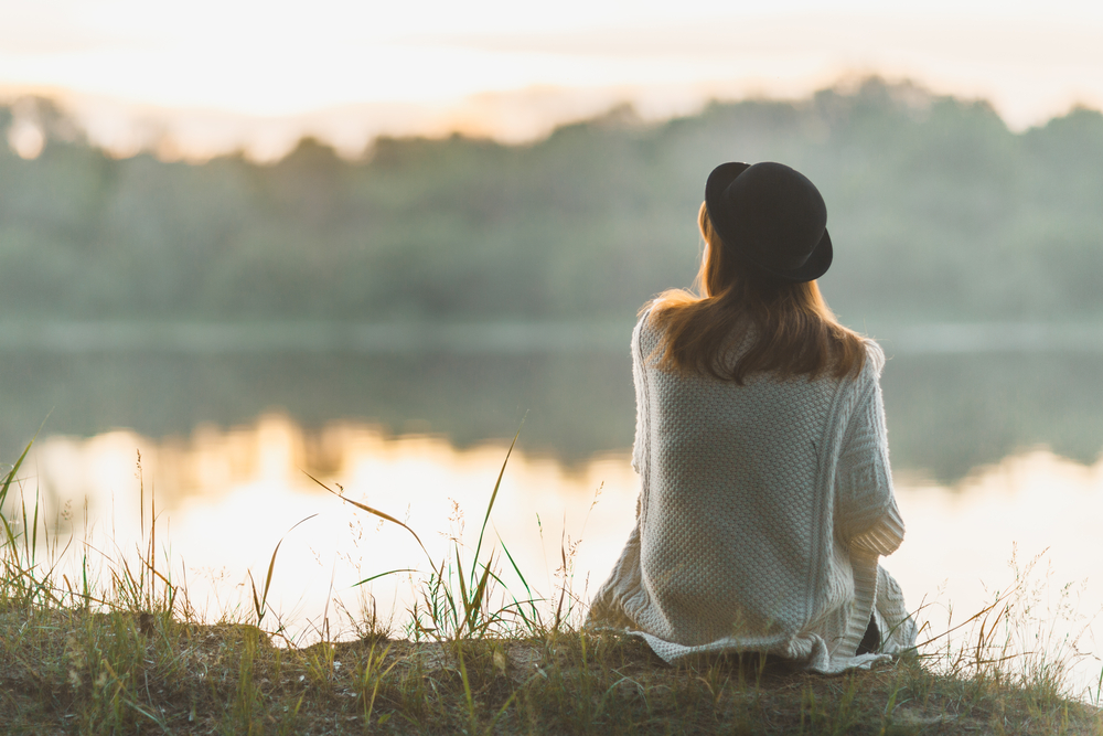 woman sitting on river bank